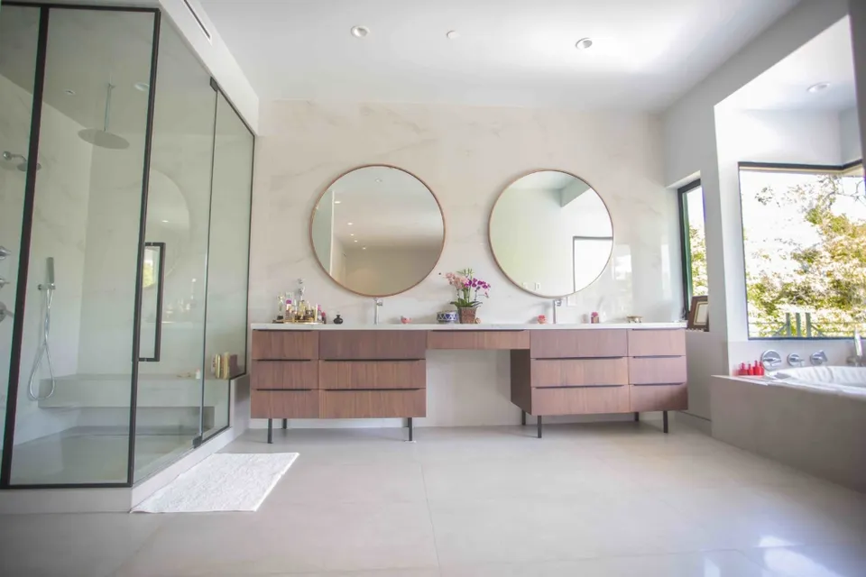 Bathroom with glass shower and round vanity mirrors